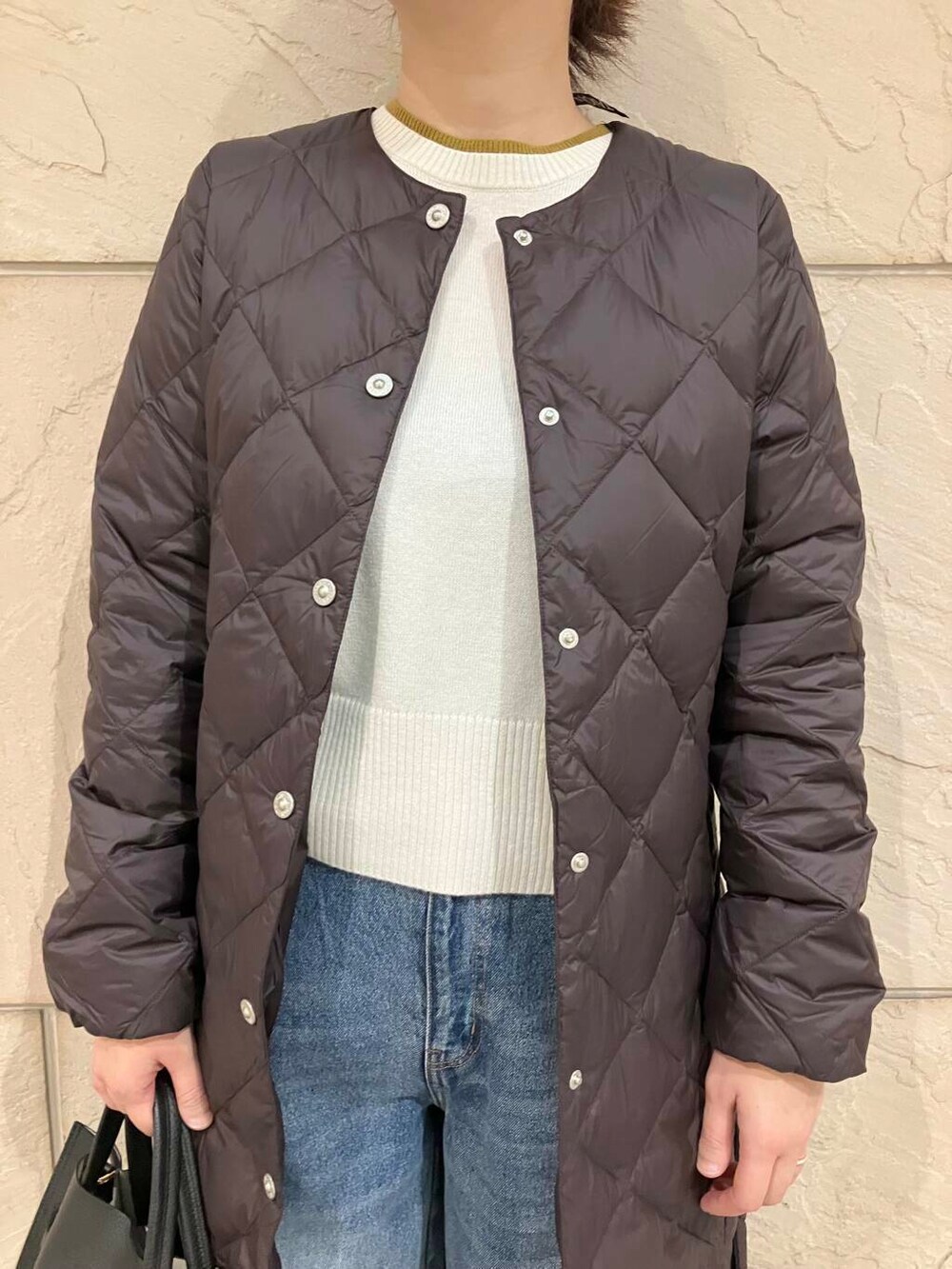 ブルー系のデニムパンツ、ホワイト系のニット/セーター、ブラック系のパンプスを着用したレディースの秋コーディネートの5枚目の写真