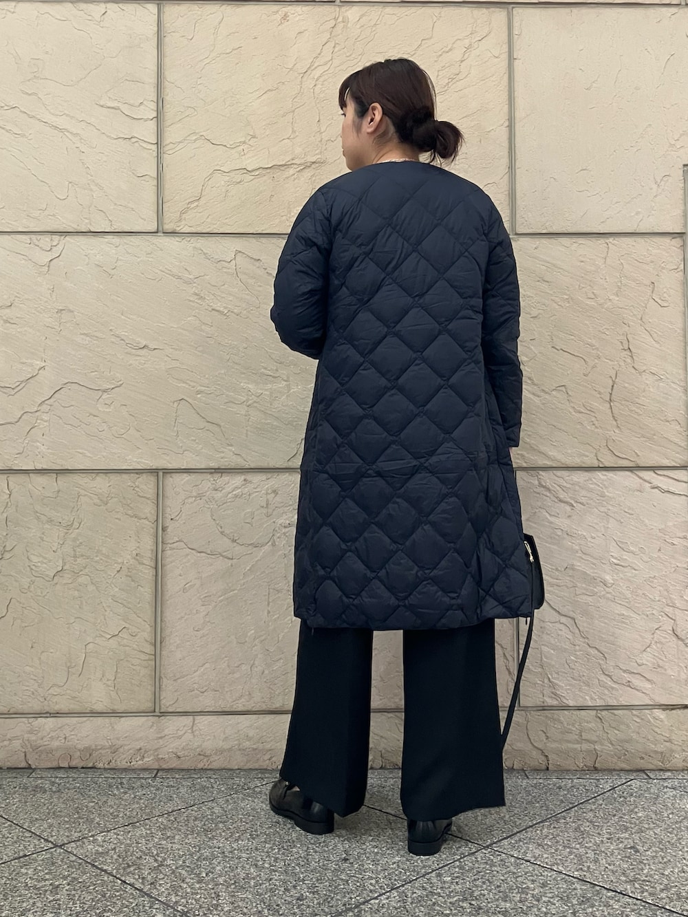 ホワイト系のカーディガン/ボレロ、ブラック系のパンツ、ブラック系のバッグを着用したレディースの秋コーディネートの3枚目の写真