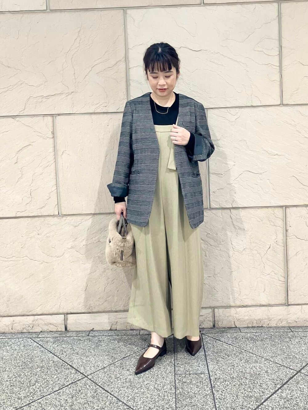 ブラック系のTシャツ/カットソー、その他のノーカラージャケット、ベージュ系のサロペット/オーバーオールを着用したレディースの秋コーディネートの2枚目の写真