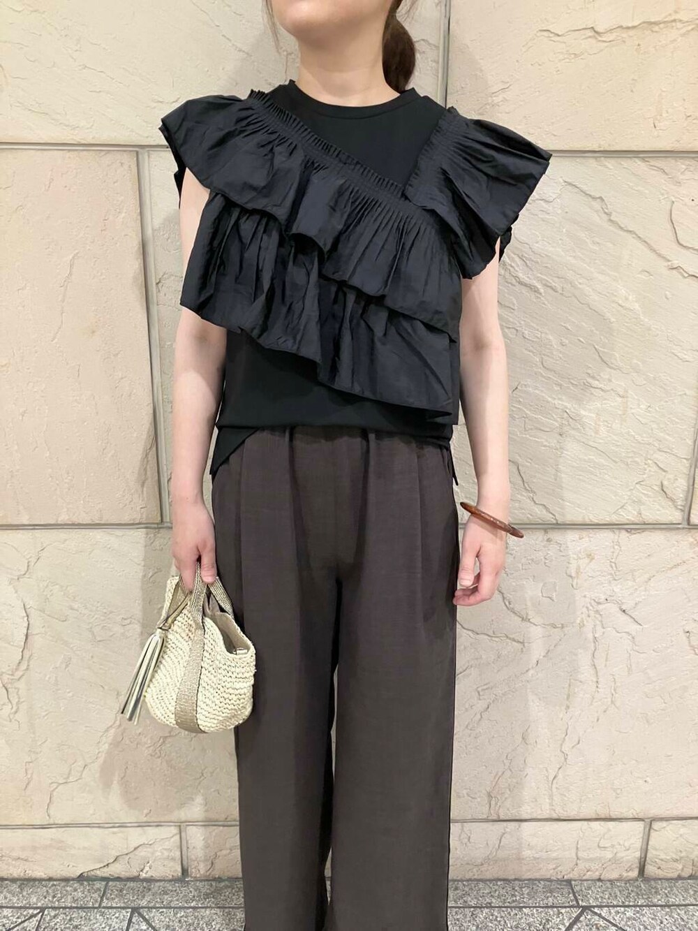 ベージュ系のかごバッグ、イエロー系のサンダル、ブラック系のTシャツ/カットソーを着用したレディースの夏コーディネートの4枚目の写真