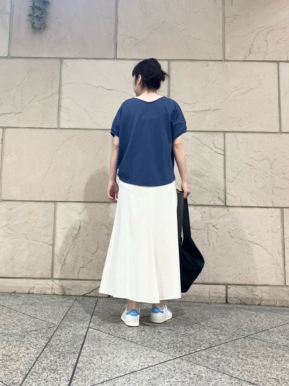 グレー系のTシャツ/カットソー、ホワイト系のスカート、ブルー系のスニーカーを着用したレディースの夏コーディネートの2枚目の写真