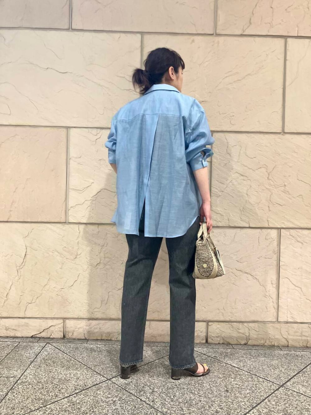 ゴールド系のかごバッグ、ブルー系のシャツ/ブラウス、ブルー系のTシャツ/カットソーを着用したレディースの春コーディネートの7枚目の写真