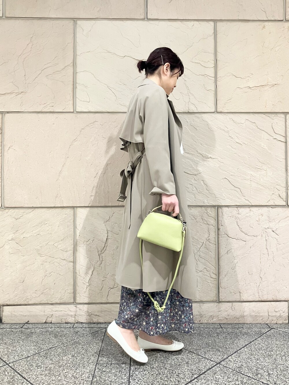 ベージュ系のトレンチコート、ブラック系のスカート、ホワイト系のシャツ/ブラウスを着用したレディースの春コーディネートの2枚目の写真