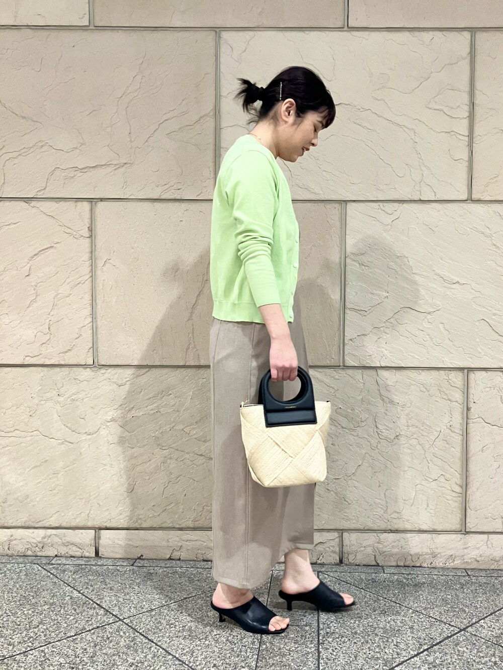 グリーン系のカーディガン/ボレロ、ベージュ系のワンピース/ドレス、ブラック系のかごバッグを着用したレディースの春コーディネートの3枚目の写真