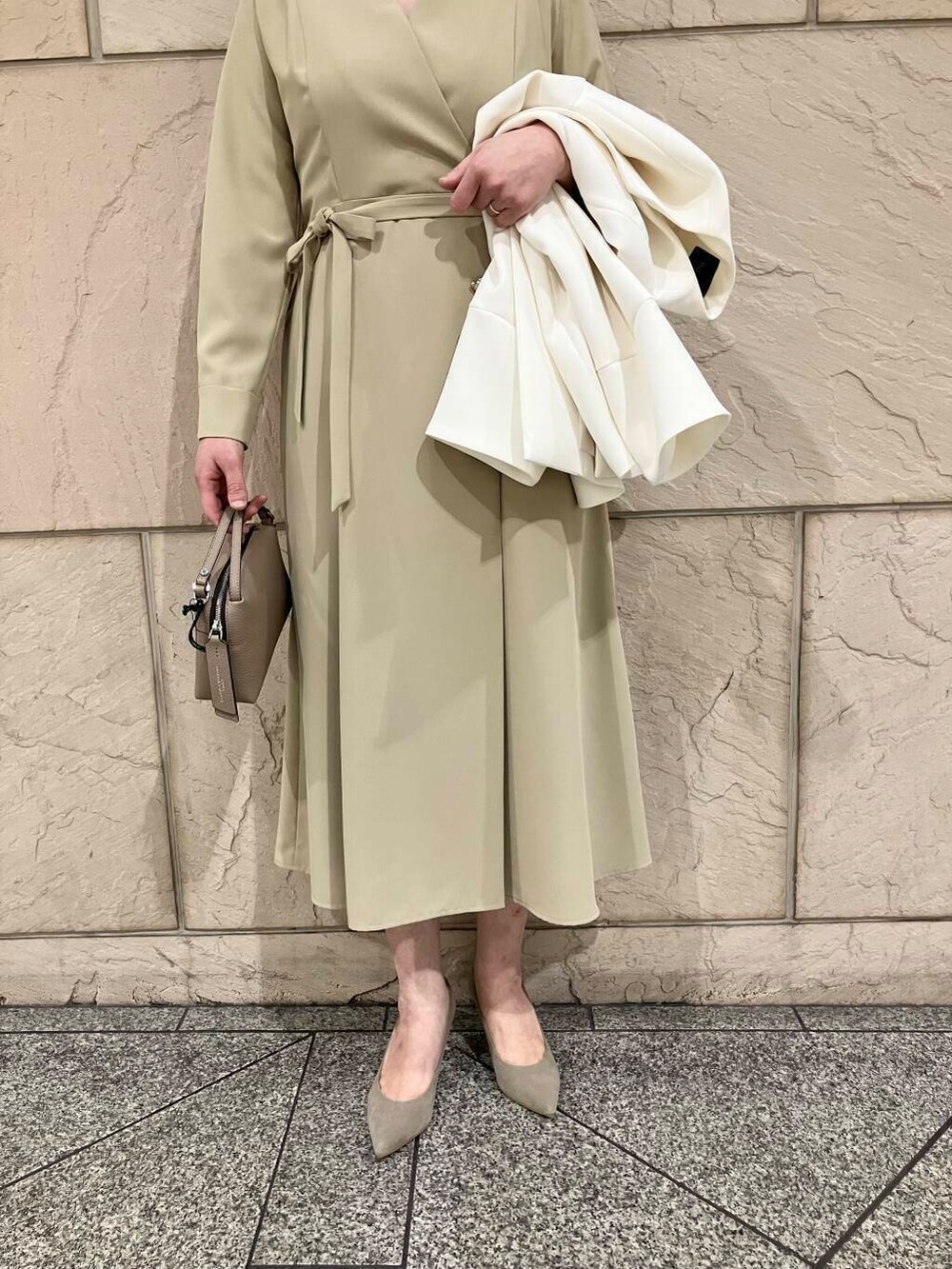 ブラウン系のパンプス、ホワイト系のノーカラージャケット、ベージュ系のワンピースを着用したレディースの冬コーディネートの5枚目の写真