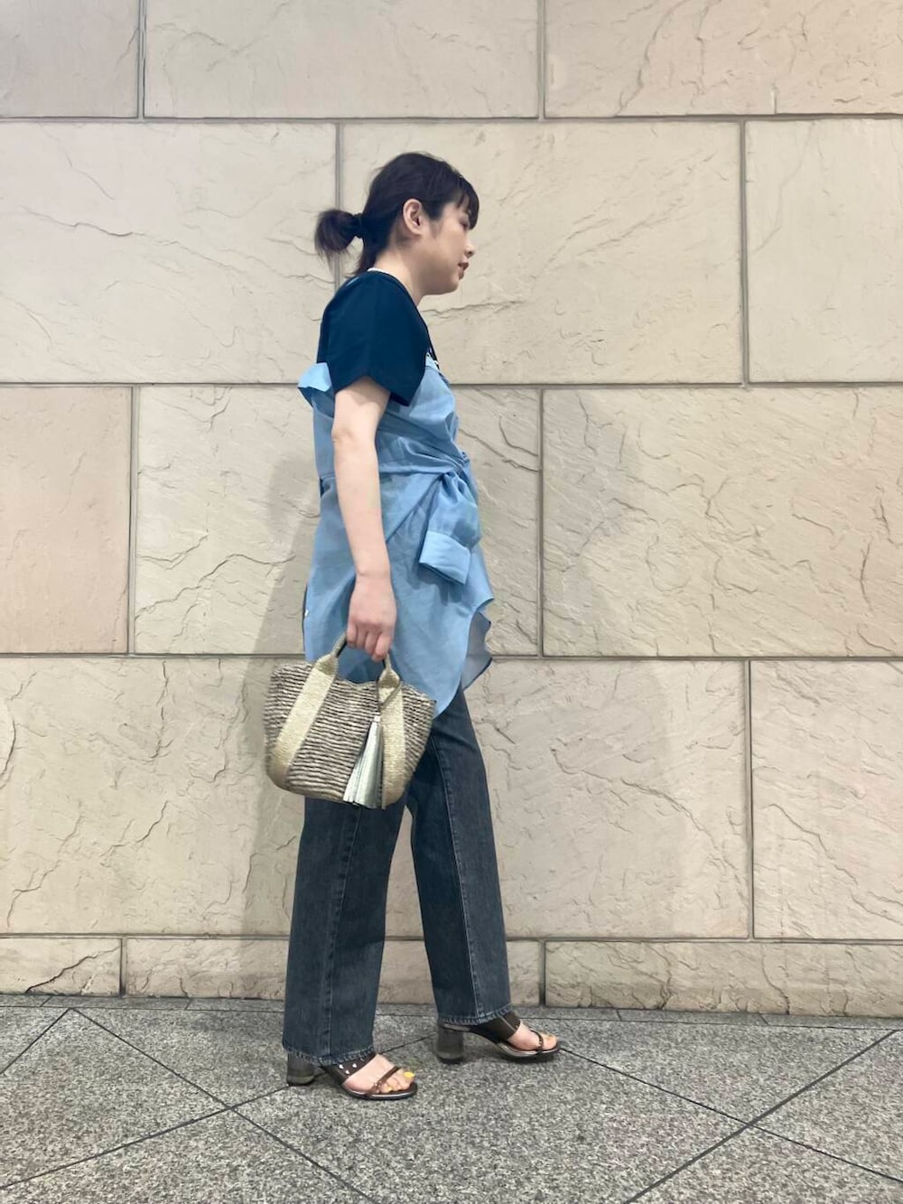 ゴールド系のかごバッグ、ブルー系のシャツ/ブラウス、ブルー系のTシャツ/カットソーを着用したレディースの春コーディネートの2枚目の写真