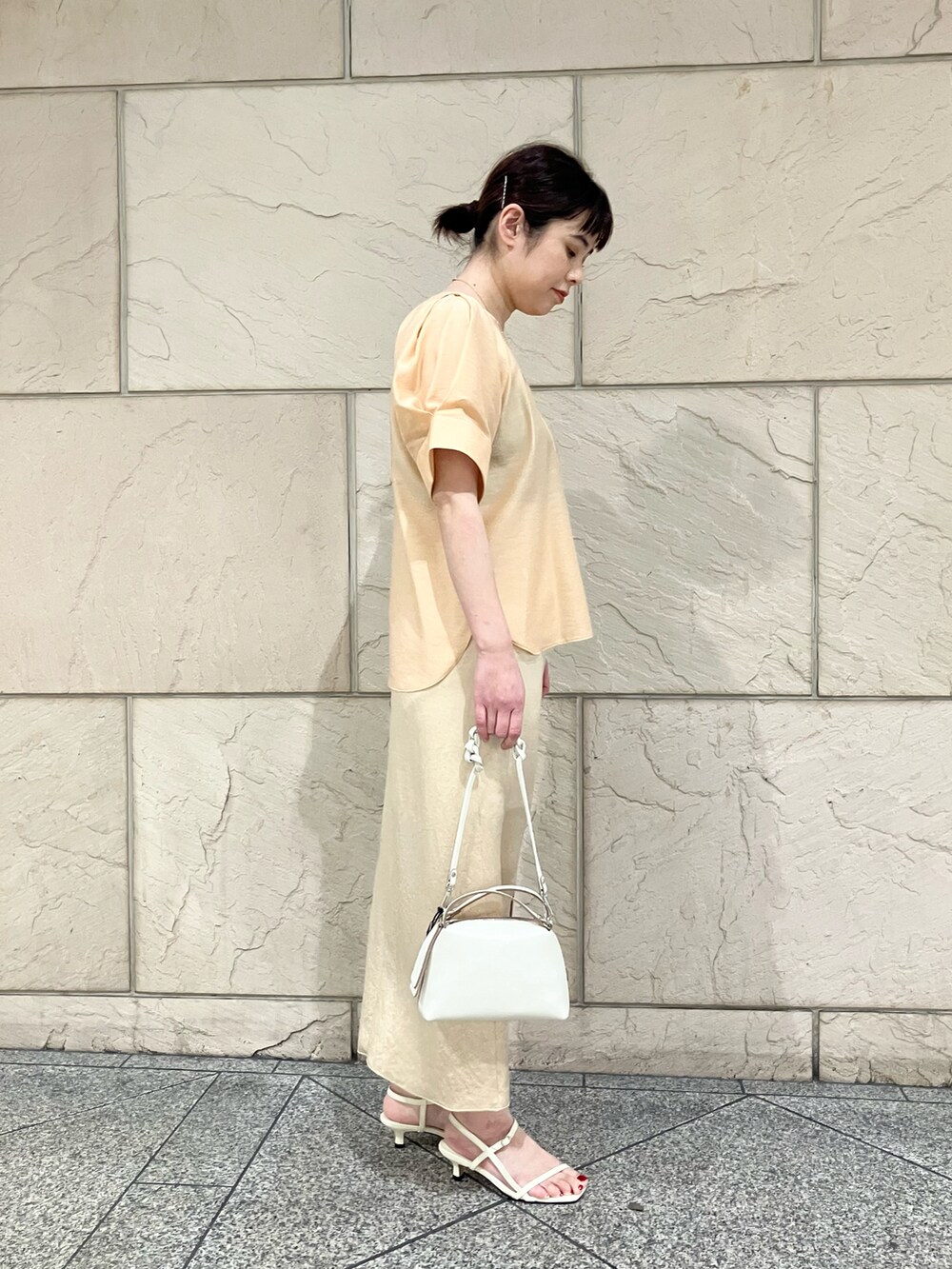 オレンジ系のシャツ/ブラウス、ホワイト系のサンダル、ベージュ系のスカートを着用したレディースの春コーディネートの3枚目の写真