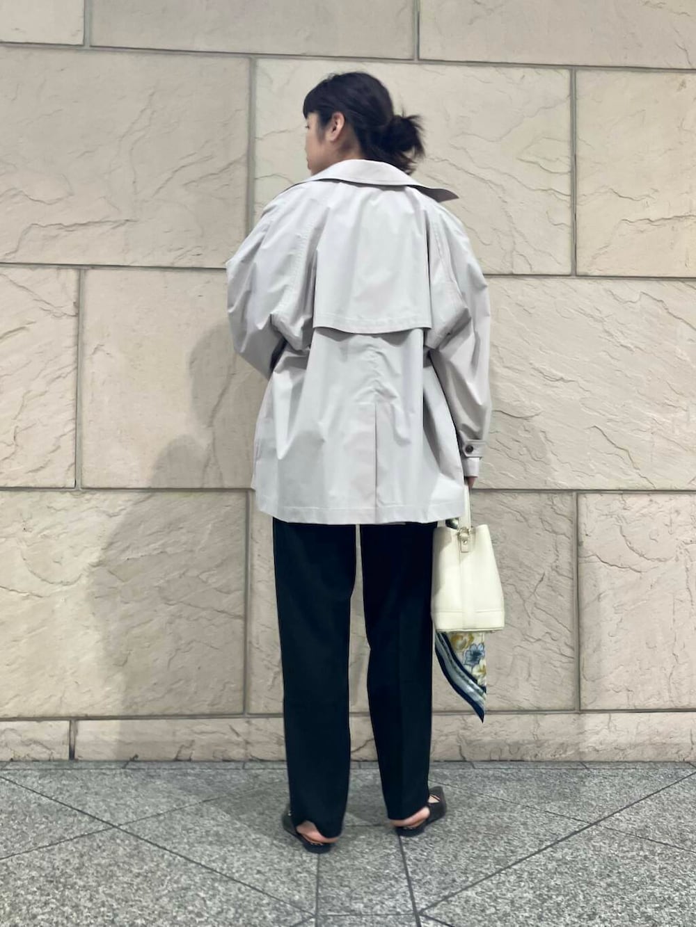 ブラック系のパンプス、ベージュ系のトレンチコート、ホワイト系のハンドバッグを着用したレディースの春コーディネートの4枚目の写真