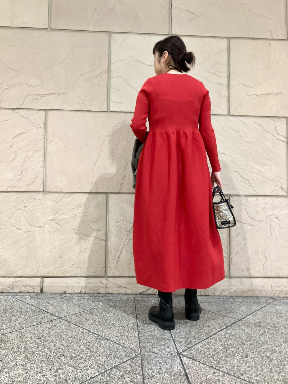 レッド系のワンピース、グレー系のその他アウター、ブラック系のブーツを着用したレディースの秋コーディネートの5枚目の写真