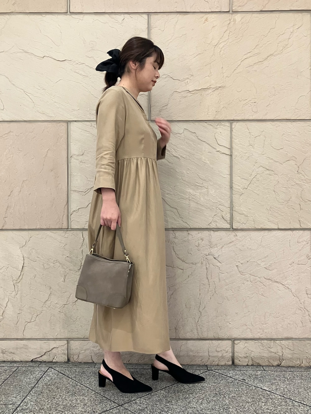 ベージュ系のワンピース、グレー系のバッグ、ブラック系のパンプスを着用したレディースの秋コーディネートの2枚目の写真