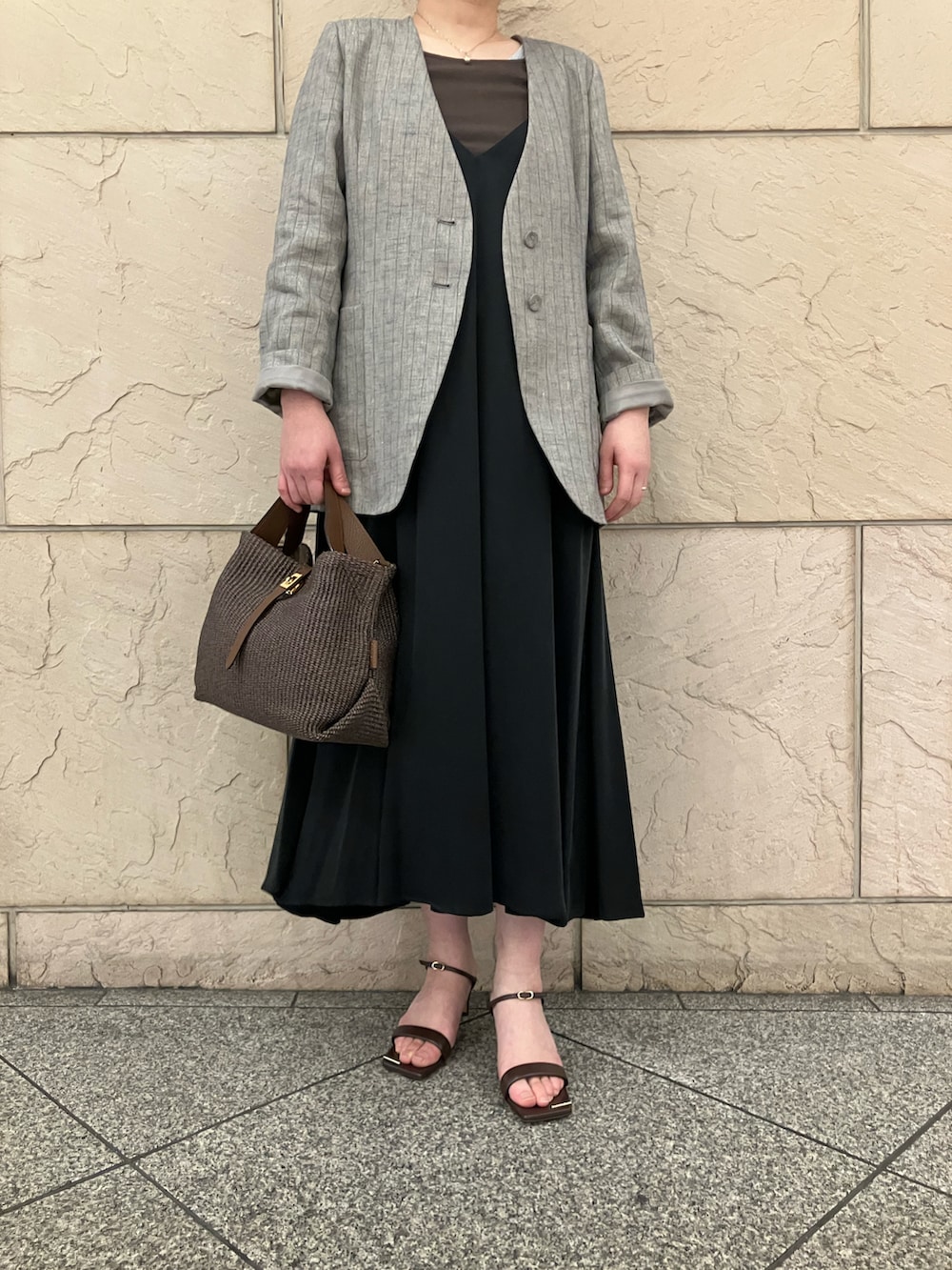 ブラウン系のタンクトップ、グレー系のノーカラージャケット、ブラック系のワンピースを着用したレディースの春コーディネートの5枚目の写真