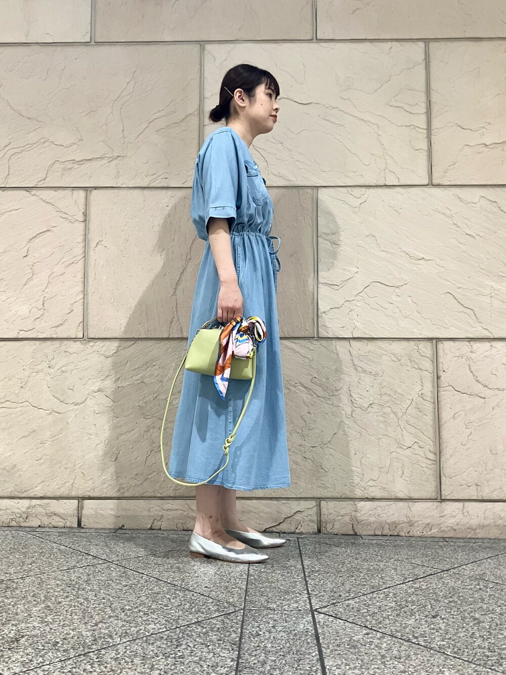 ブルー系のワンピース、グリーン系のショルダーバッグ、ゴールド系のネックレスを着用したレディースの春コーディネートの2枚目の写真