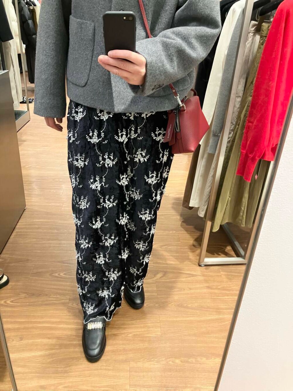 ホワイト系のニット/セーター、グレー系のその他アウター、レッド系のショルダーバッグを着用したレディースの冬コーディネートの4枚目の写真