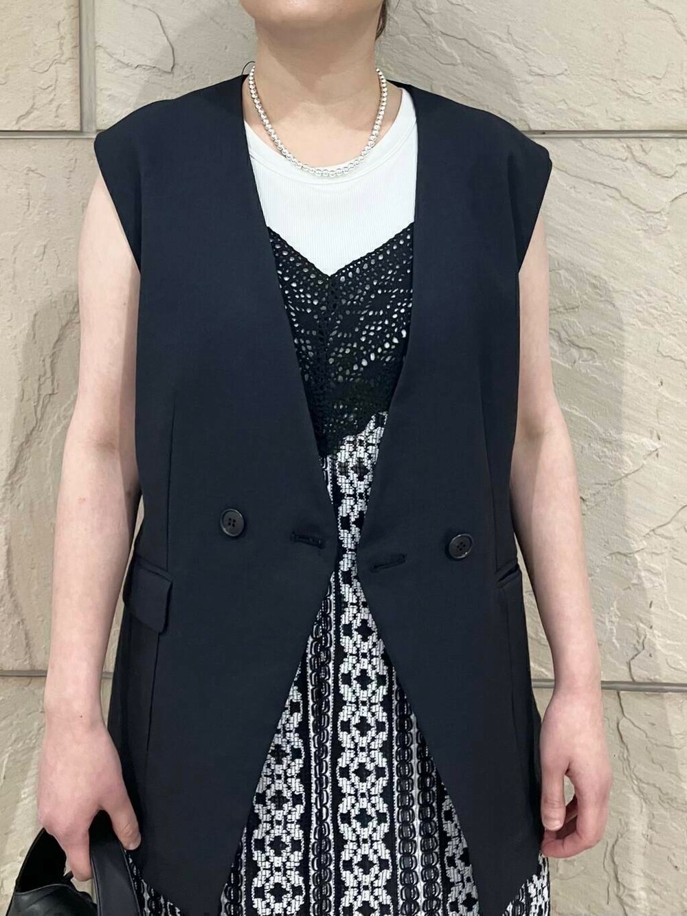 グレー系のその他パンツ、ブラック系のハンドバッグ、グレー系のベストを着用したレディースの春コーディネートの3枚目の写真