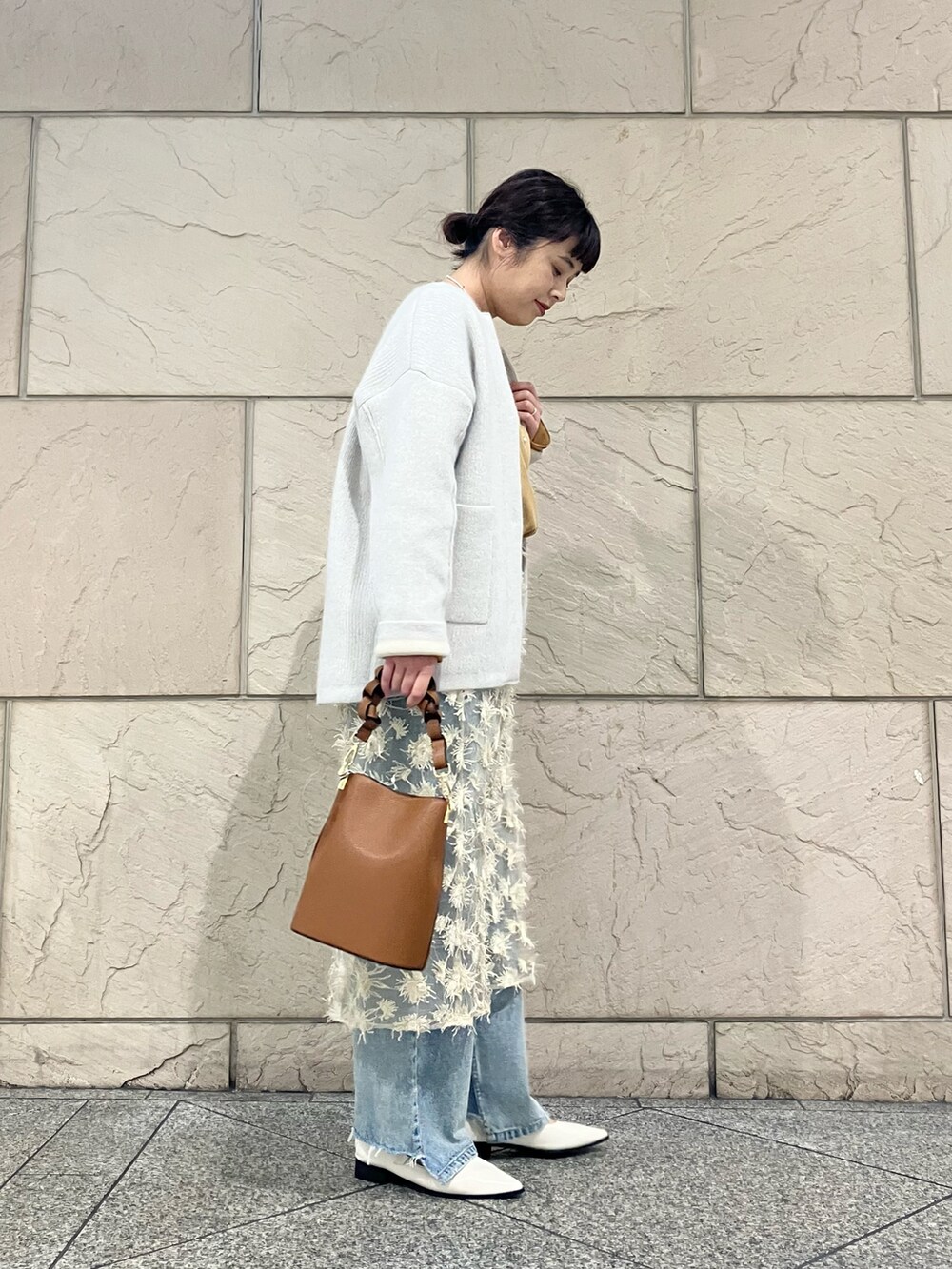 イエロー系のシャツ/ブラウス、グレー系のカーディガン/ボレロ、ベージュ系のスカートを着用したレディースの秋コーディネートの3枚目の写真