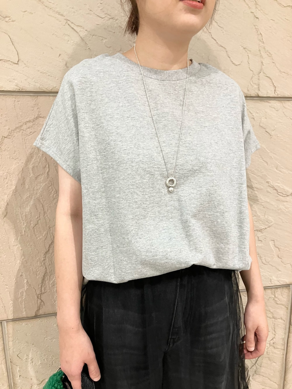 グレー系のスウェット、ブラック系のスカート、グレー系のデニムパンツを着用したレディースの夏コーディネートの4枚目の写真