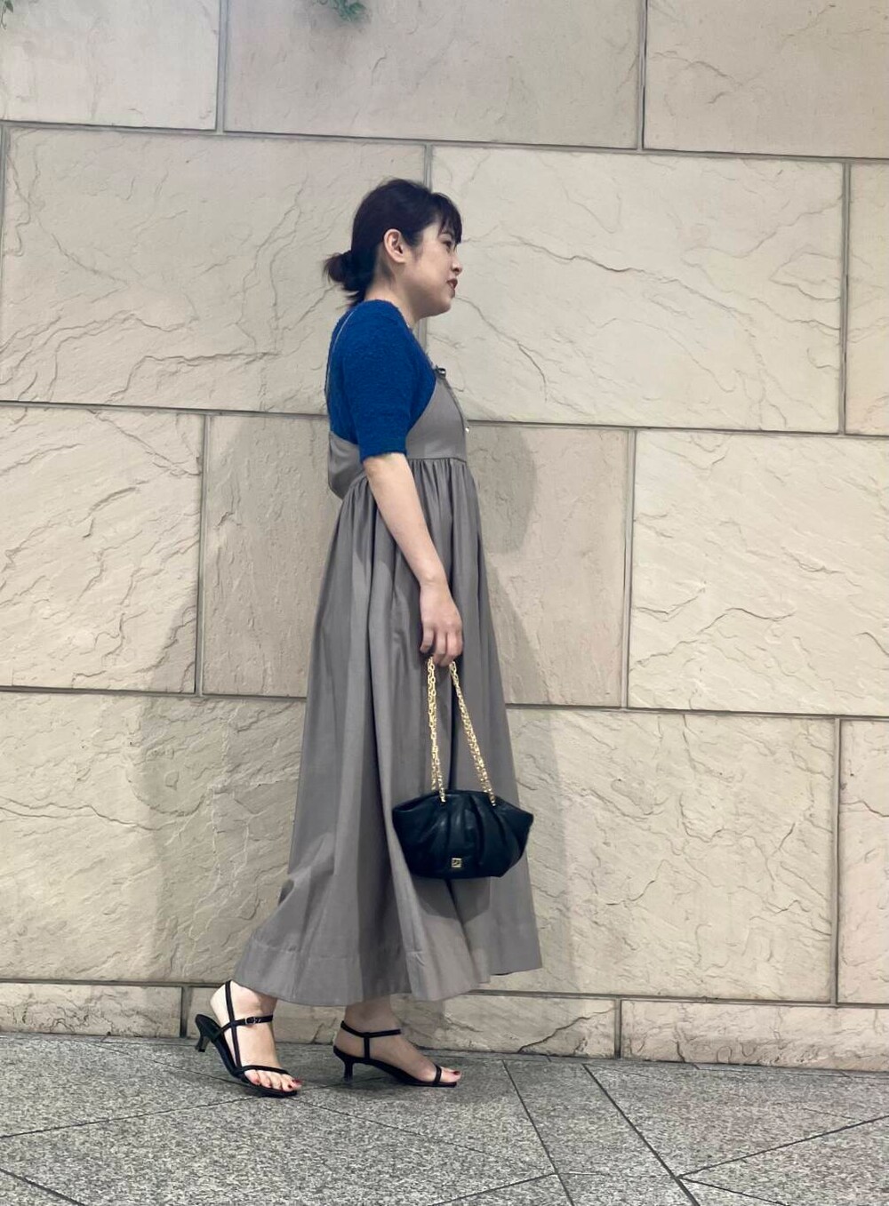 ブラウン系のワンピース、ブラック系のハンドバッグ、ブルー系のニット/セーターを着用したレディースの夏コーディネートの2枚目の写真