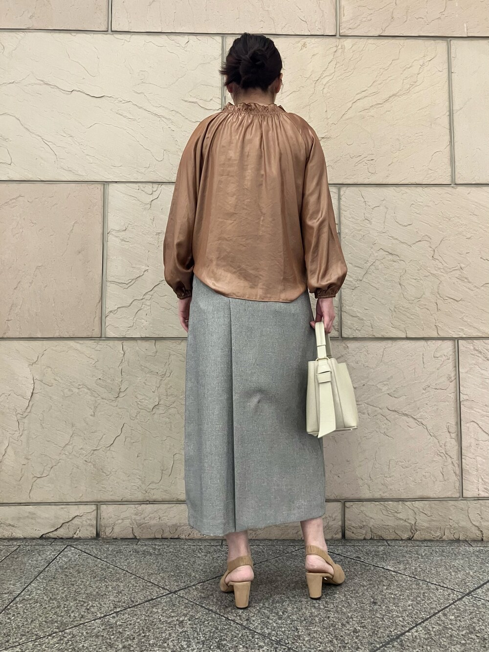 イエロー系のシャツ/ブラウス、グレー系のスカート、ホワイト系のバッグを着用したレディースの秋コーディネートの3枚目の写真