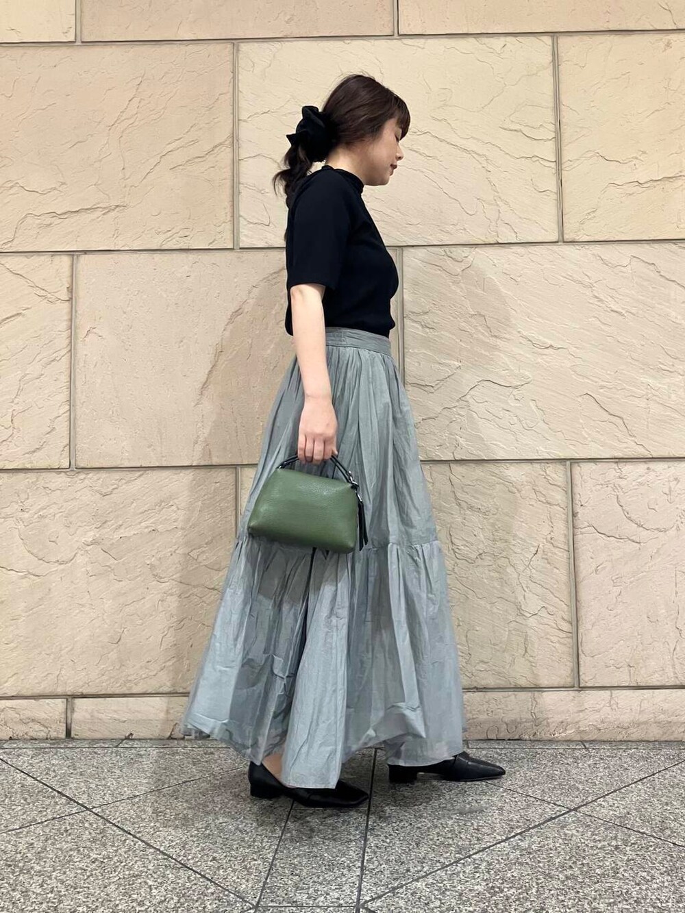 ブラック系のTシャツ/カットソー、グレー系のスカート、グリーン系のショルダーバッグを着用したレディースの夏コーディネートの3枚目の写真