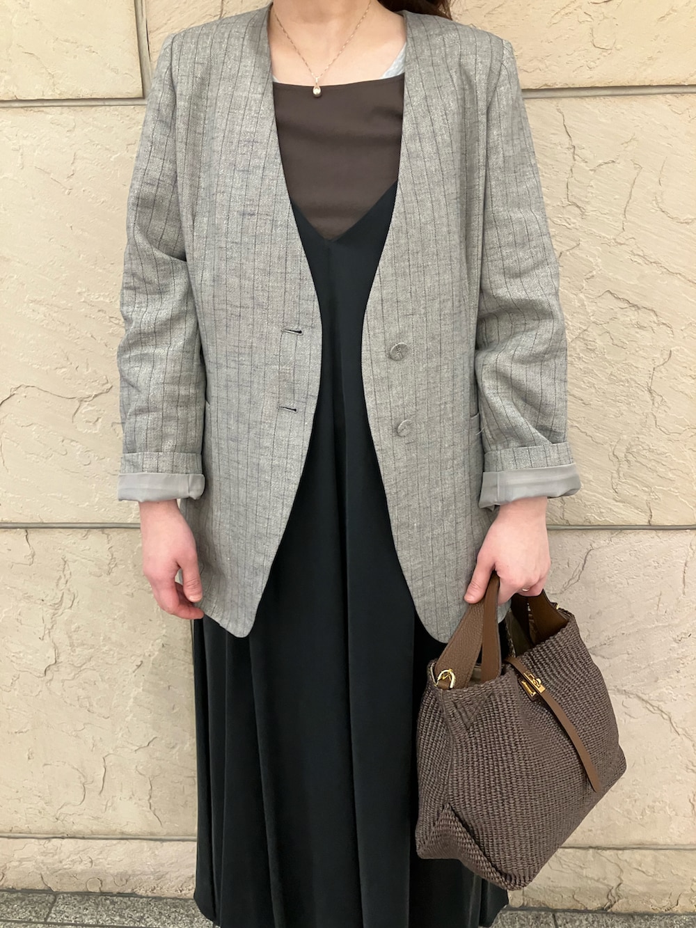 ブラウン系のタンクトップ、グレー系のノーカラージャケット、ブラック系のワンピースを着用したレディースの春コーディネートの4枚目の写真