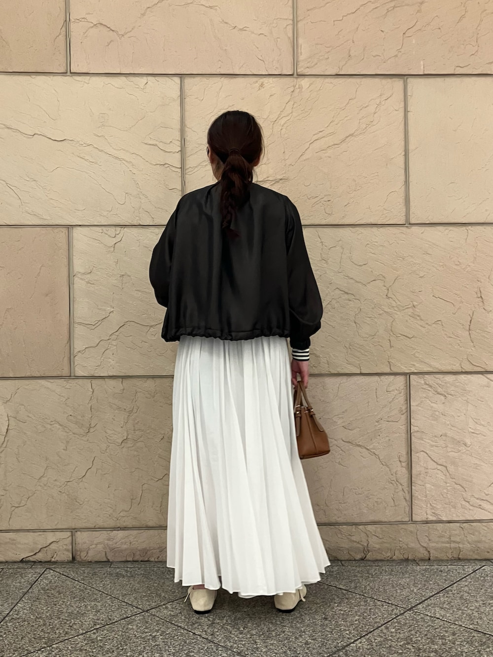 ホワイト系のTシャツ/カットソー、ブラウン系のブルゾン、ホワイト系のスカートを着用したレディースの春コーディネートの3枚目の写真