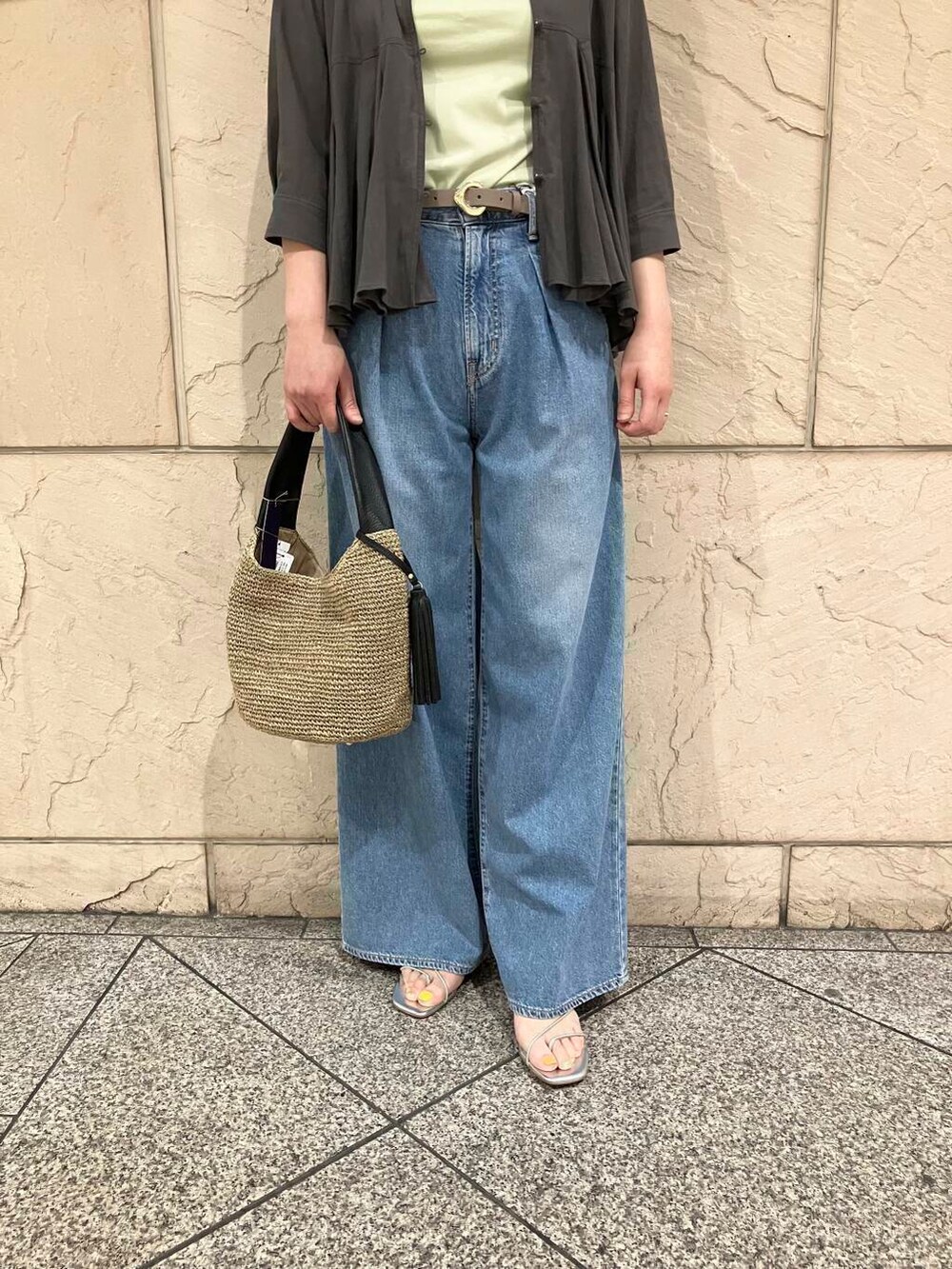 ブラウン系のかごバッグ、グリーン系のTシャツ/カットソー、ブルー系のデニムパンツを着用したレディースの夏コーディネートの5枚目の写真