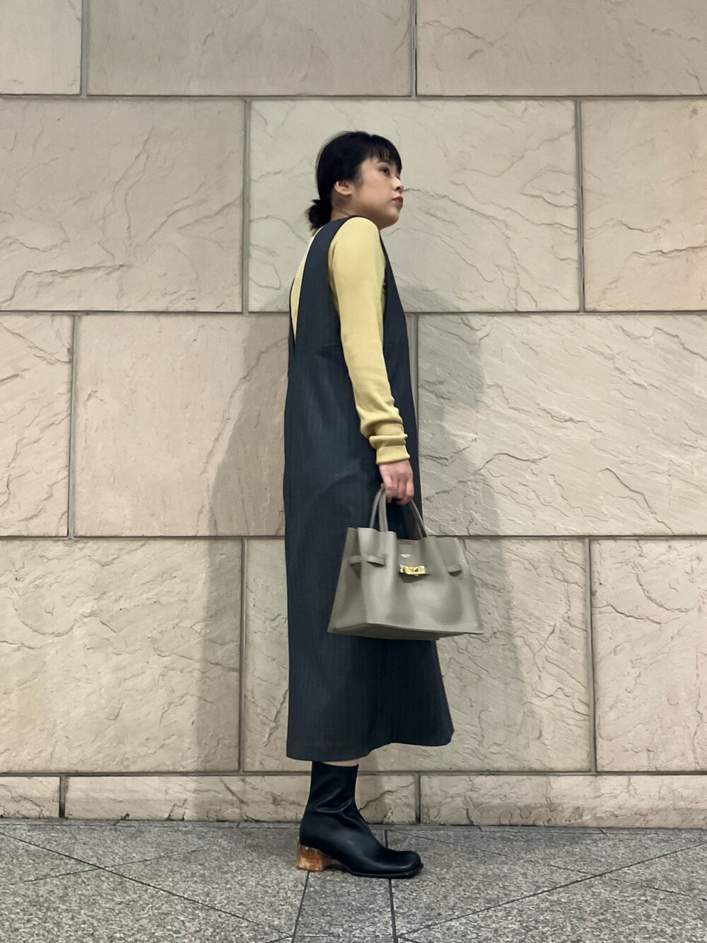 グレー系のワンピース、イエロー系のニット/セーター、ベージュ系のトートバッグを着用したレディースの秋コーディネートの2枚目の写真