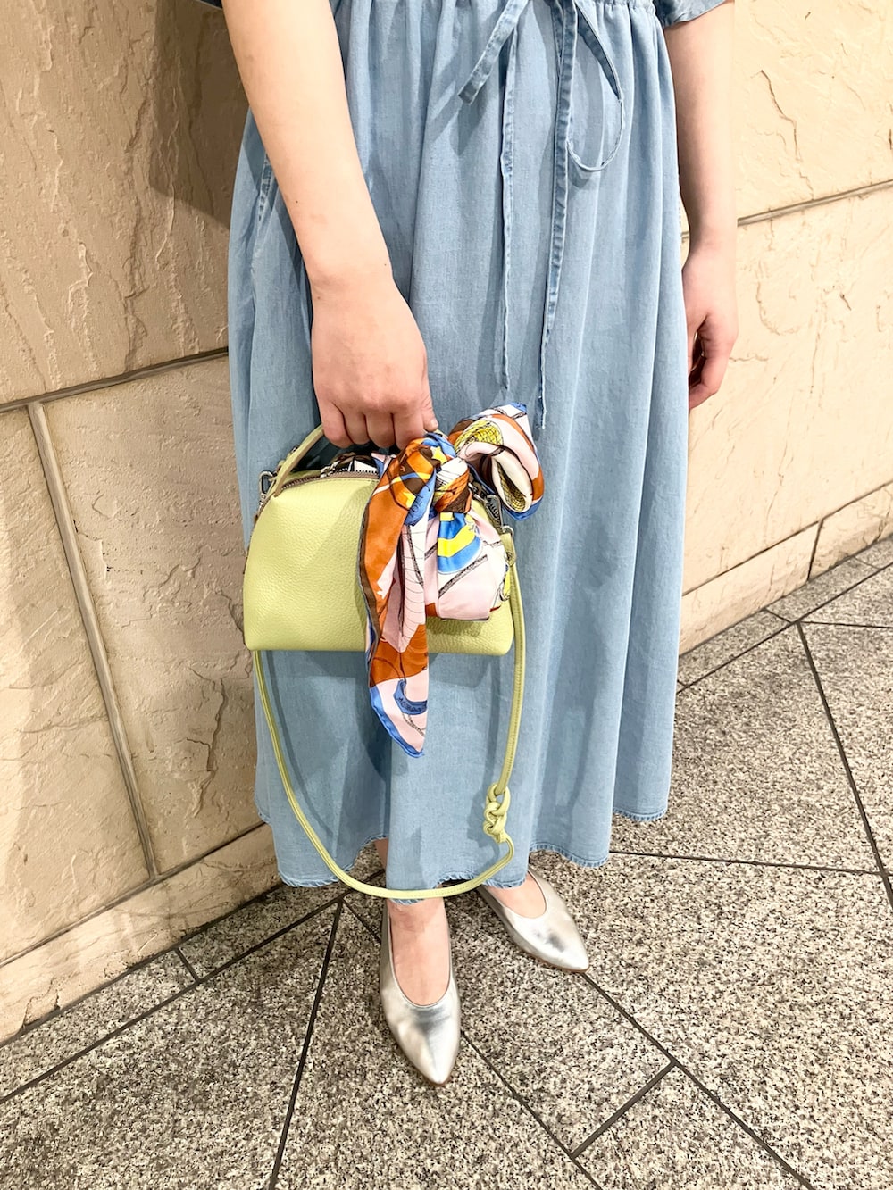 ブルー系のワンピース、グリーン系のショルダーバッグ、ゴールド系のネックレスを着用したレディースの春コーディネートの5枚目の写真