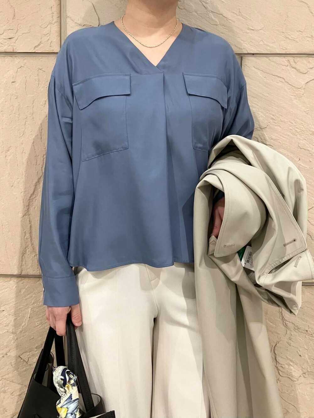 グレー系のトレンチコート、ベージュ系のパンプス、ブラック系のトートバッグを着用したレディースの春コーディネートの6枚目の写真