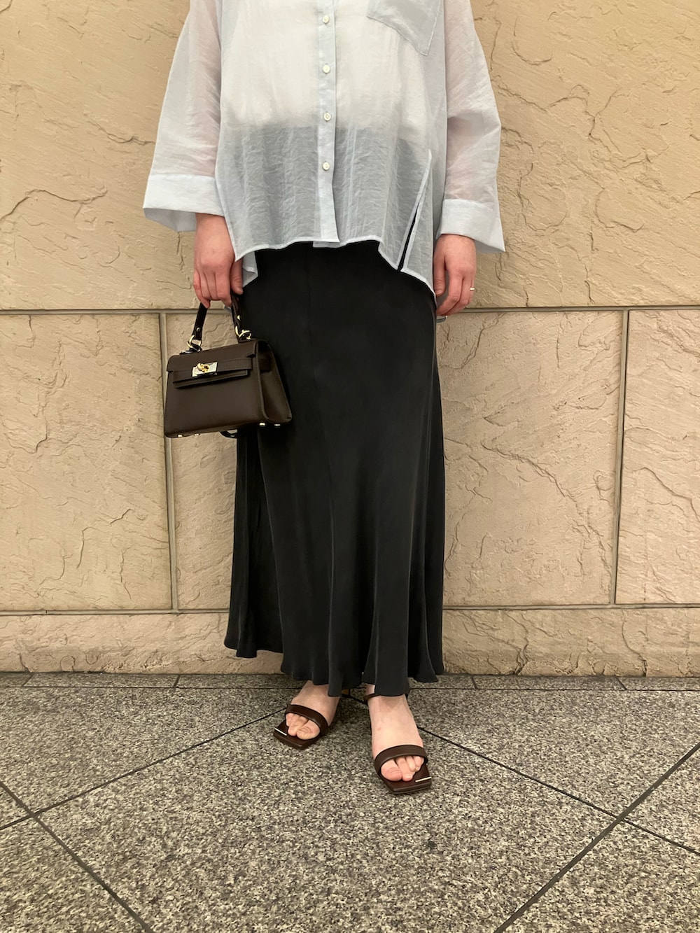 ホワイト系のキャミソール、ブラック系のスカート、ブルー系のトップスを着用したレディースの春コーディネートの5枚目の写真