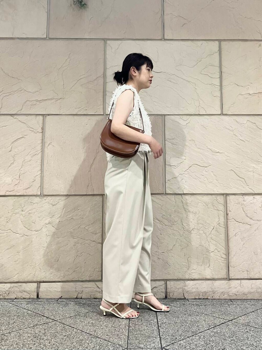 ホワイト系のサンダル、ホワイト系のTシャツ/カットソー、ベージュ系のその他パンツを着用したレディースの夏コーディネートの2枚目の写真