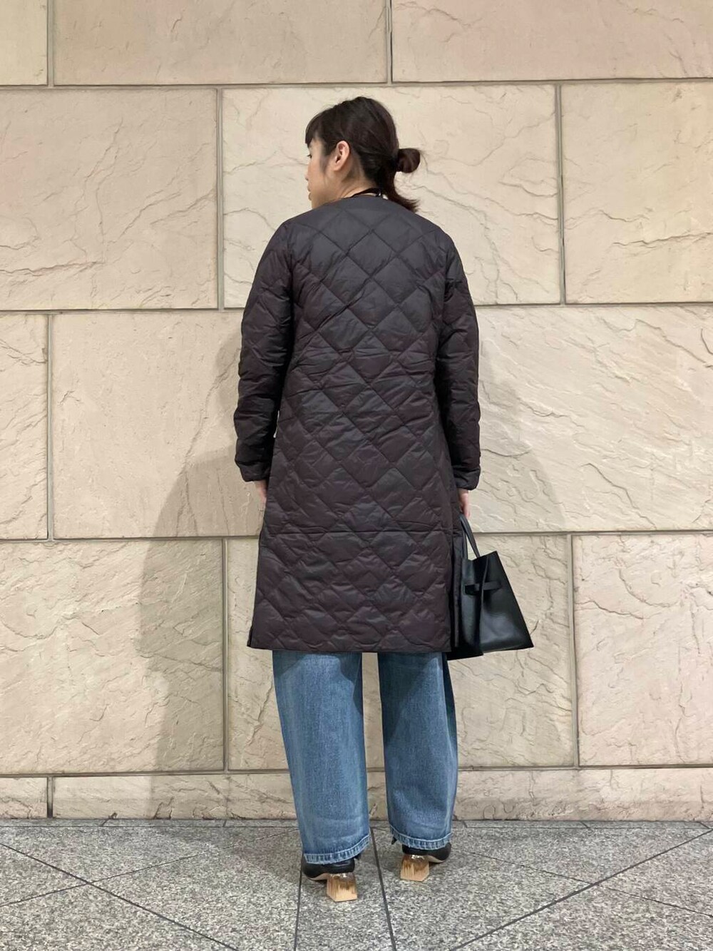 ブルー系のデニムパンツ、ホワイト系のニット/セーター、ブラック系のパンプスを着用したレディースの秋コーディネートの3枚目の写真