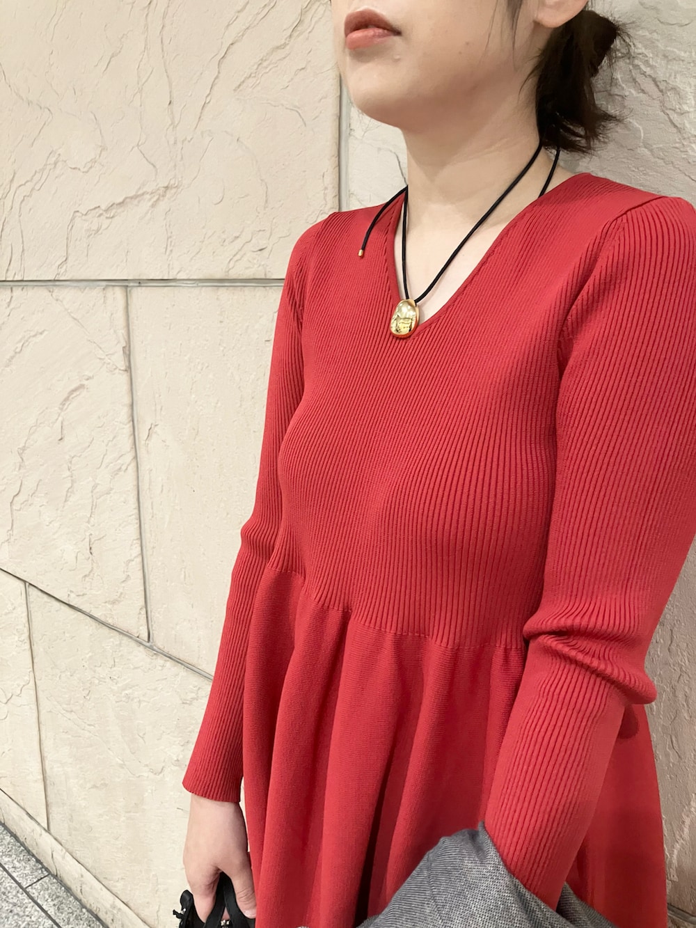 レッド系のワンピース、グレー系のその他アウター、ブラック系のブーツを着用したレディースの秋コーディネートの2枚目の写真