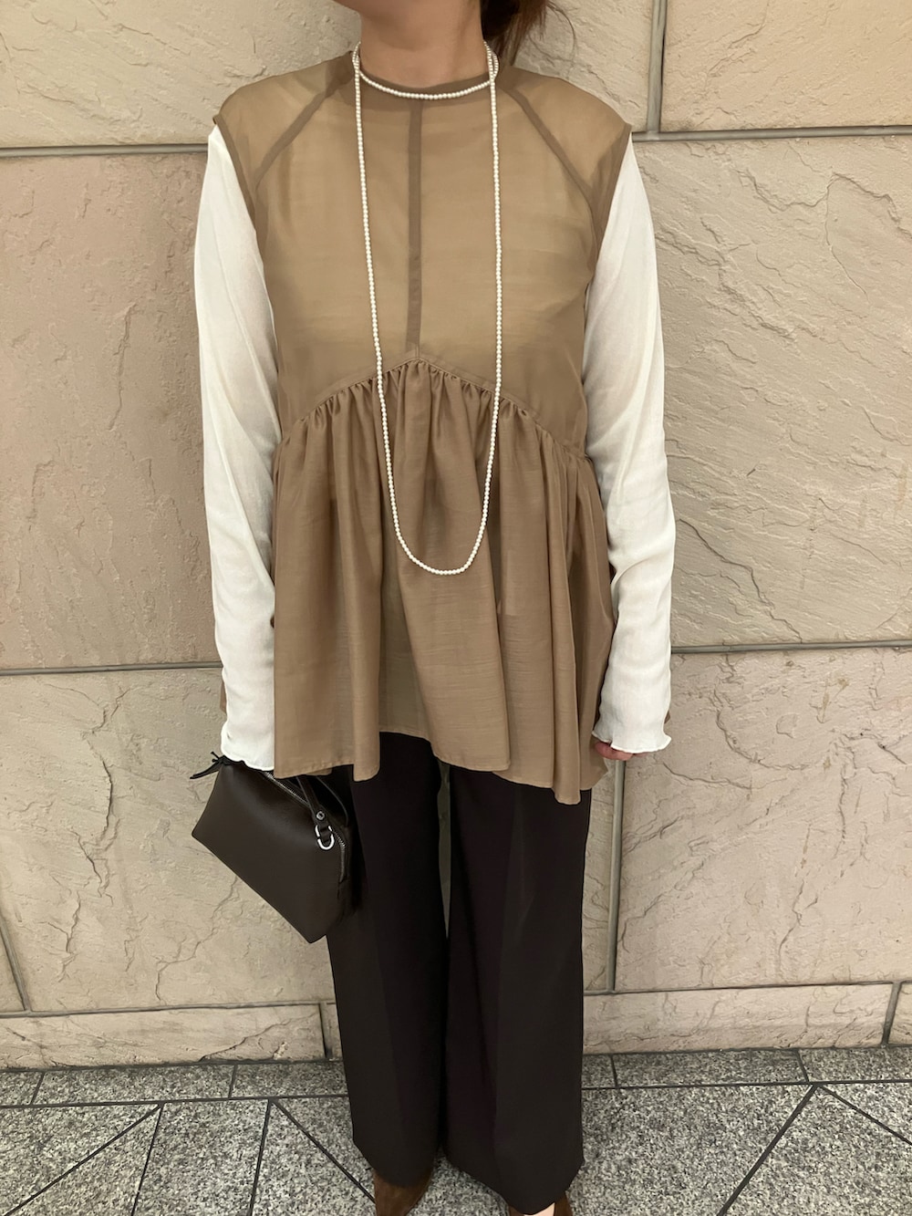 ベージュ系のシャツ/ブラウス、ブラウン系のその他パンツ、ホワイト系のTシャツ/カットソーを着用したレディースの秋コーディネートの4枚目の写真