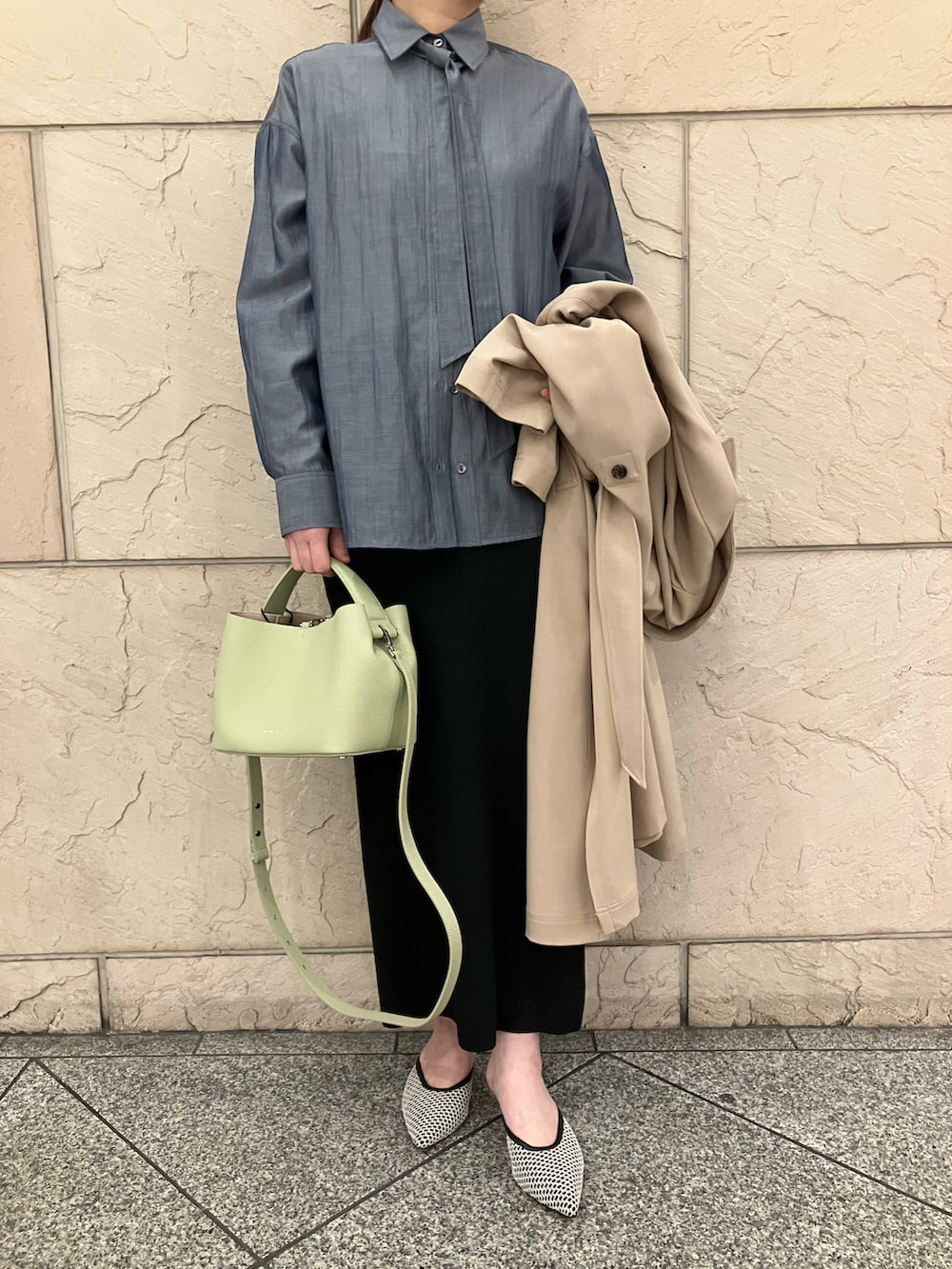 ブルー系のシャツ/ブラウス、ブラック系のスカート、ベージュ系のトレンチコートを着用したレディースの冬コーディネートの5枚目の写真