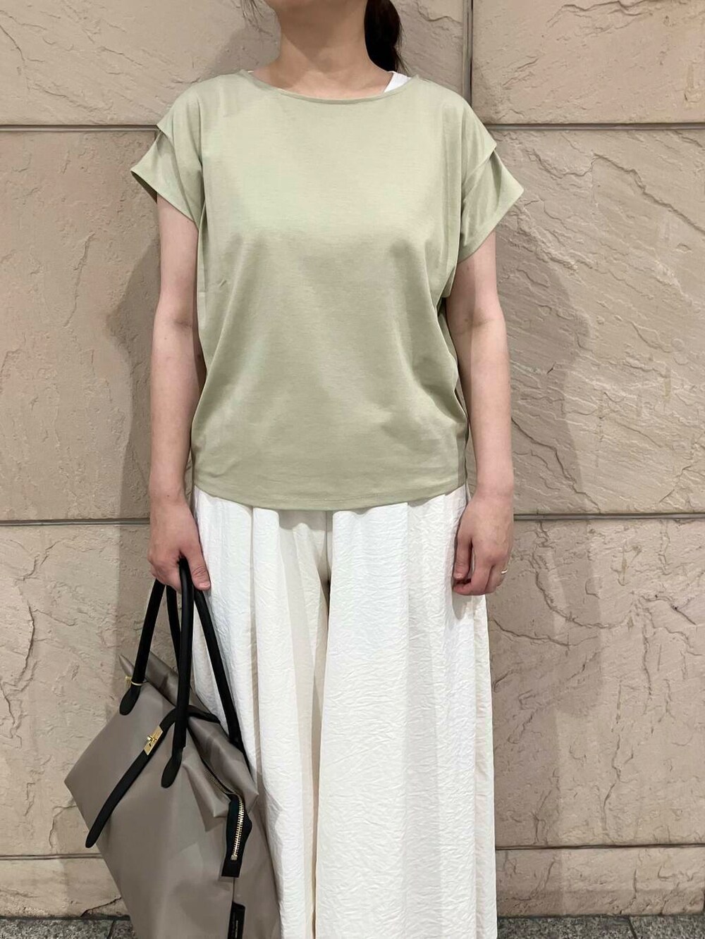 グレー系のローファー、ホワイト系のその他パンツ、グリーン系のTシャツ/カットソーを着用したレディースの夏コーディネートの4枚目の写真