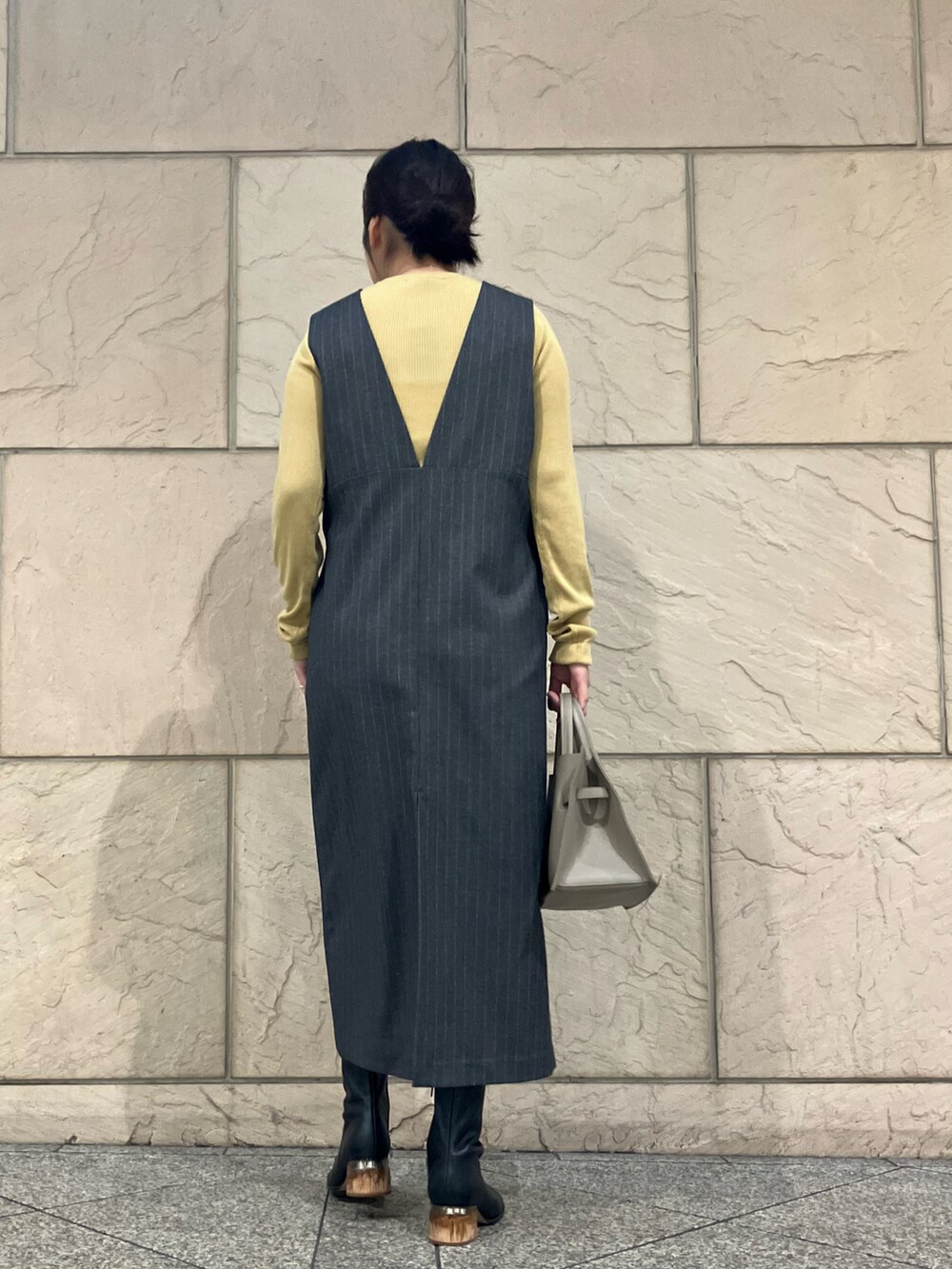 グレー系のワンピース、イエロー系のニット/セーター、ベージュ系のトートバッグを着用したレディースの秋コーディネートの3枚目の写真