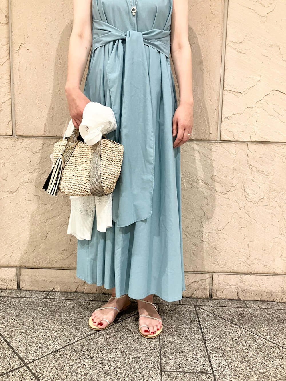 ブルー系のワンピース、ゴールド系のかごバッグ、ホワイト系のカーディガン/ボレロを着用したレディースの夏コーディネートの3枚目の写真