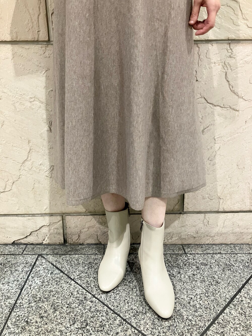 ベージュ系のワンピース、ホワイト系のブーツ、ゴールド系のネックレスを着用したレディースの秋コーディネートの4枚目の写真