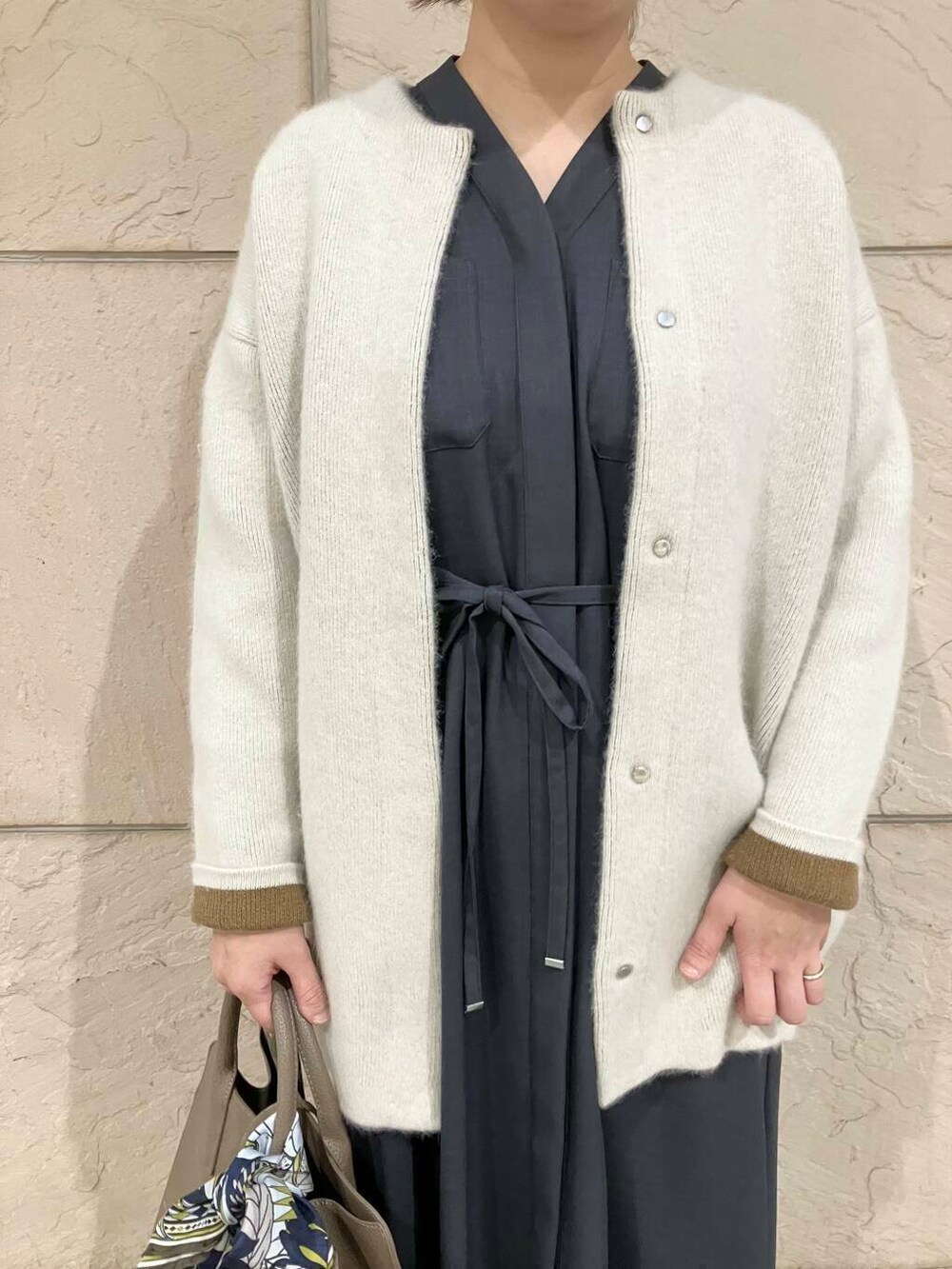 グレー系のワンピース、グレー系のカーディガン/ボレロ、ブラック系のブーツを着用したレディースの秋コーディネートの3枚目の写真