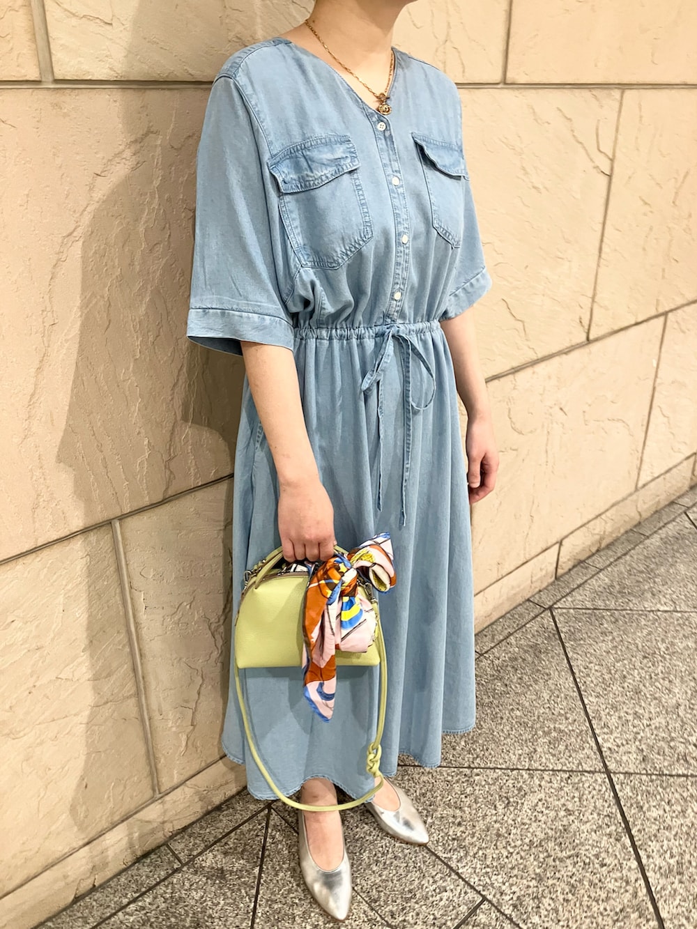 ブルー系のワンピース、グリーン系のショルダーバッグ、ゴールド系のネックレスを着用したレディースの春コーディネートの4枚目の写真