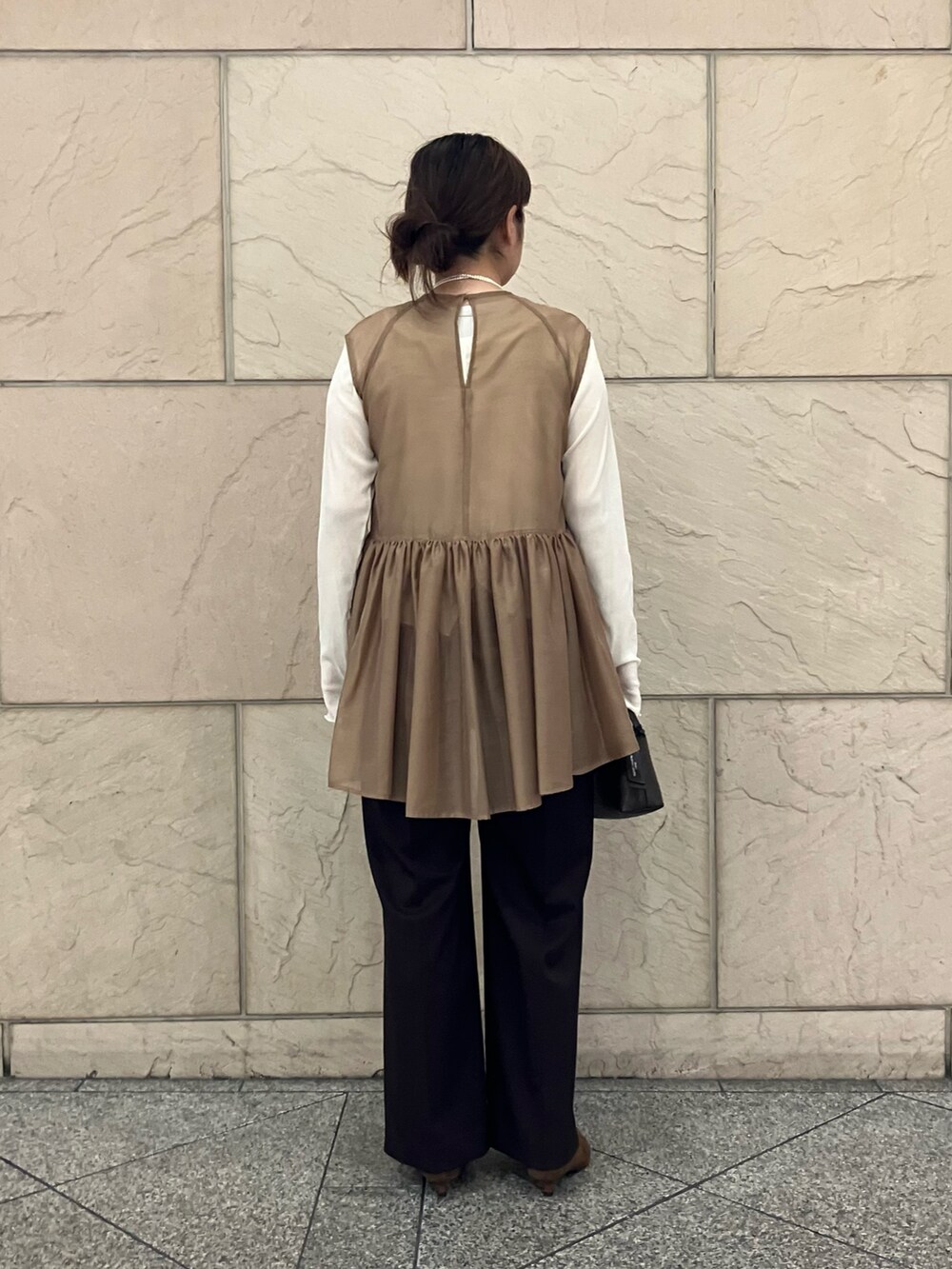 ベージュ系のシャツ/ブラウス、ブラウン系のその他パンツ、ホワイト系のTシャツ/カットソーを着用したレディースの秋コーディネートの3枚目の写真