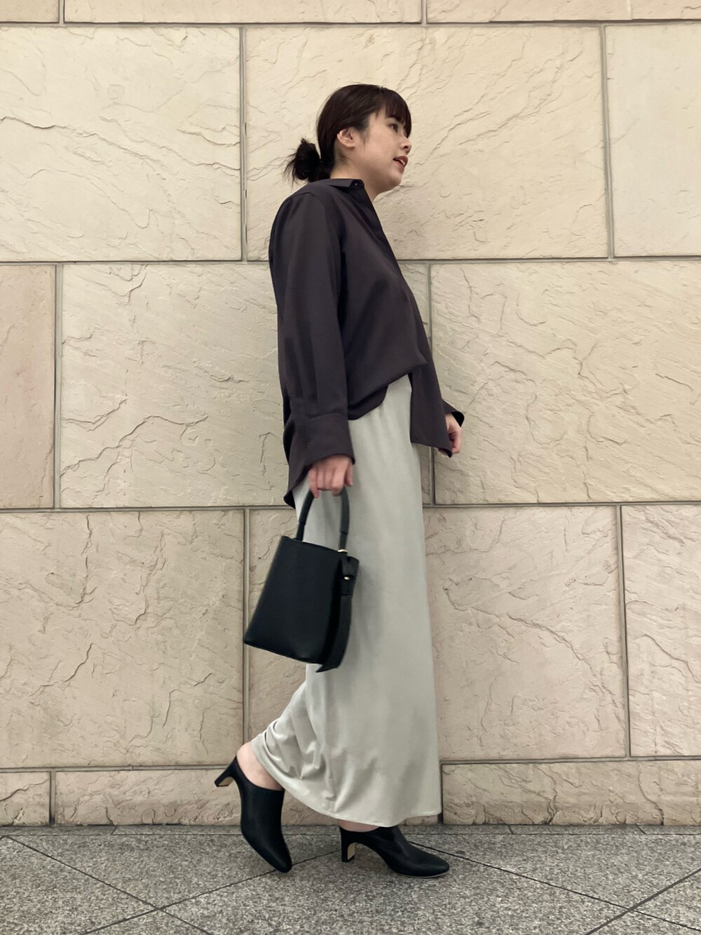 レッド系のシャツ/ブラウス、ベージュ系のスカート、ブラック系のハンドバッグを着用したレディースの秋コーディネートの2枚目の写真