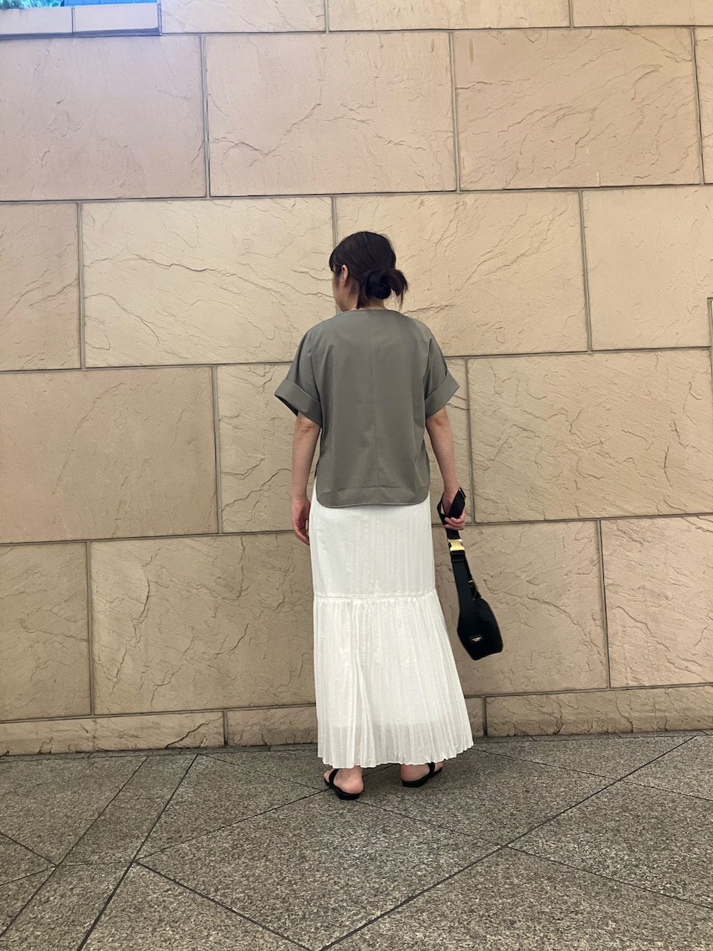 ブラウン系のTシャツ/カットソー、ホワイト系のスカート、ブラック系のショルダーバッグを着用したレディースの夏コーディネートの3枚目の写真