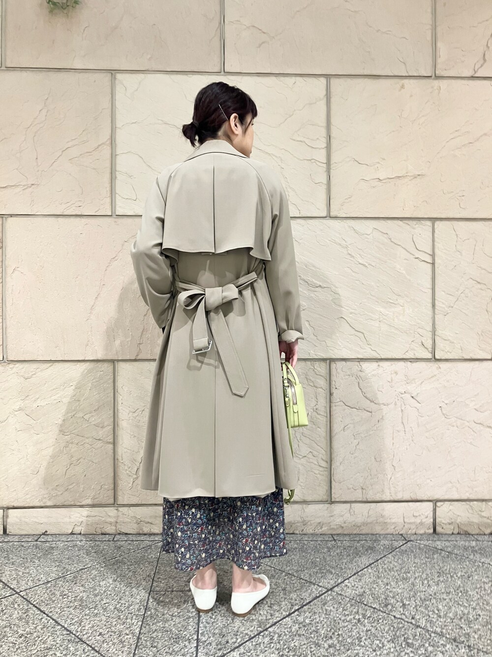 ベージュ系のトレンチコート、ブラック系のスカート、ホワイト系のシャツ/ブラウスを着用したレディースの春コーディネートの3枚目の写真