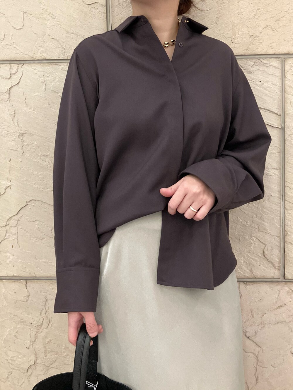 レッド系のシャツ/ブラウス、ベージュ系のスカート、ブラック系のハンドバッグを着用したレディースの秋コーディネートの4枚目の写真