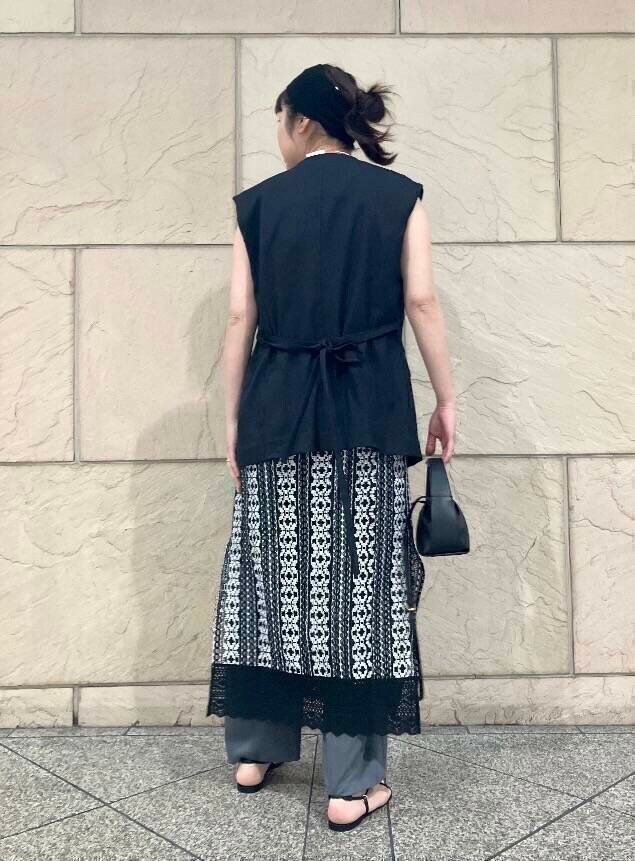 グレー系のその他パンツ、ブラック系のハンドバッグ、グレー系のベストを着用したレディースの春コーディネートの2枚目の写真