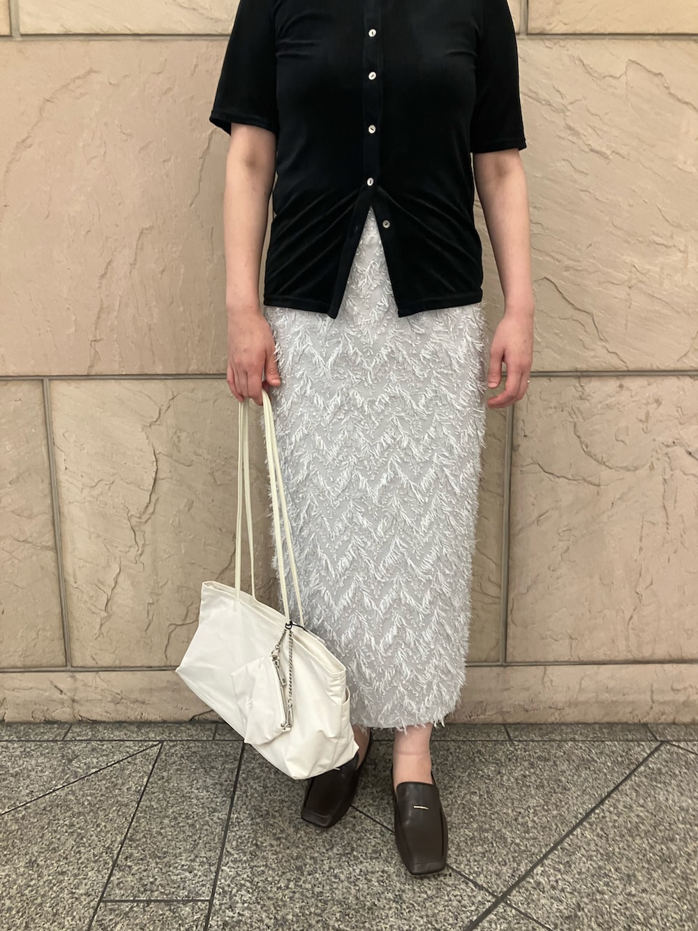 グレー系のスカート、ブラック系のTシャツ/カットソー、ホワイト系のトートバッグを着用したレディースの夏コーディネートの5枚目の写真