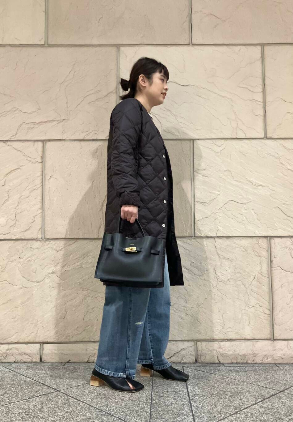 ブルー系のデニムパンツ、ホワイト系のニット/セーター、ブラック系のパンプスを着用したレディースの秋コーディネートの2枚目の写真