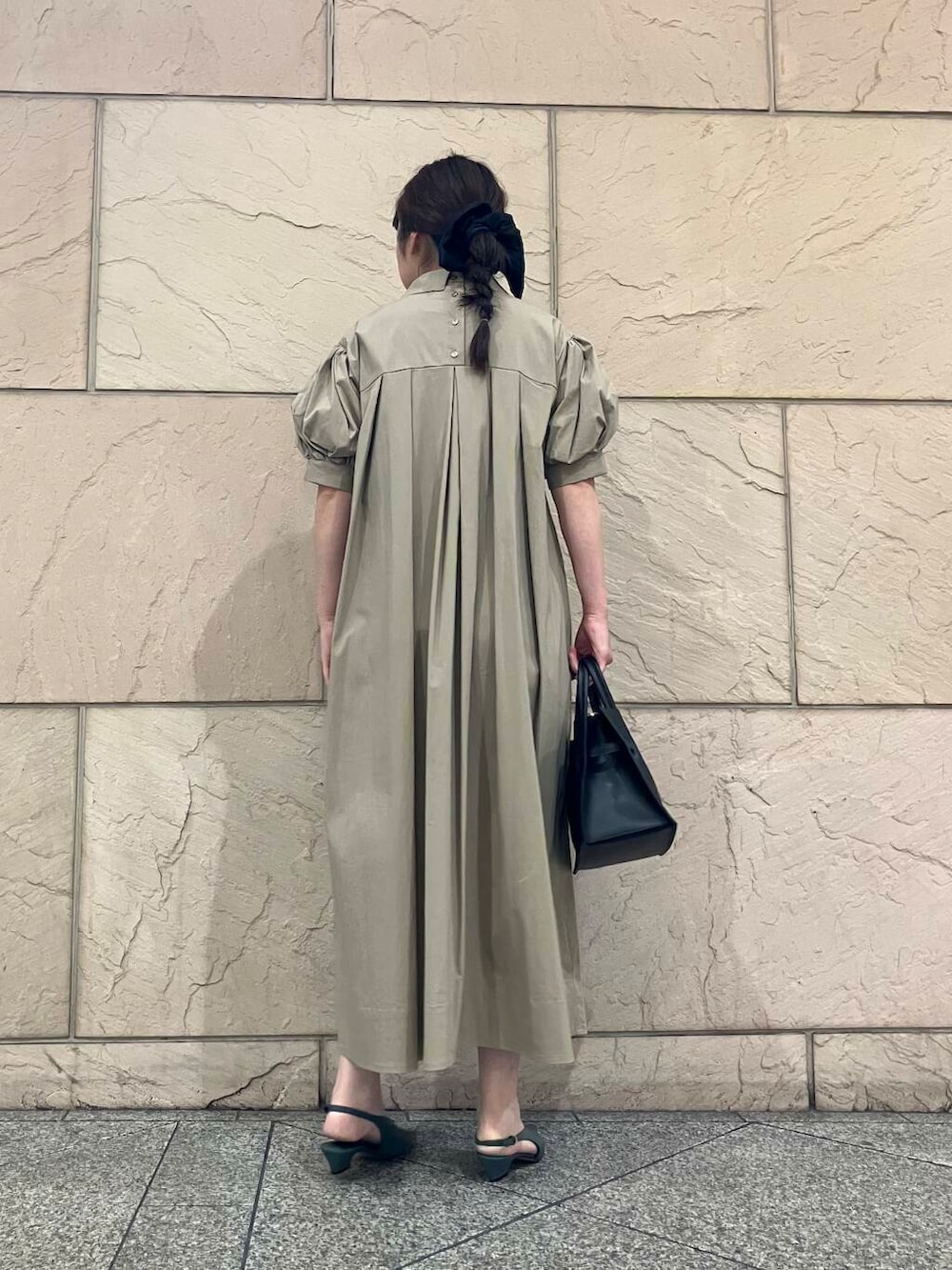 ベージュ系のワンピース、ブラック系のトートバッグ、グリーン系のパンプスを着用したレディースの夏コーディネートの3枚目の写真